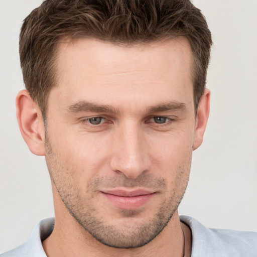 Joyful white young-adult male with short  brown hair and grey eyes