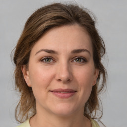 Joyful white young-adult female with medium  brown hair and green eyes