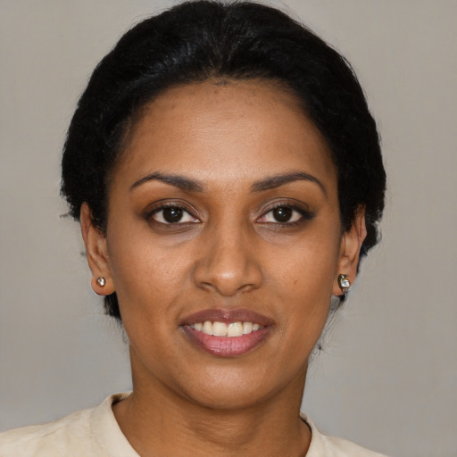 Joyful black young-adult female with short  brown hair and brown eyes