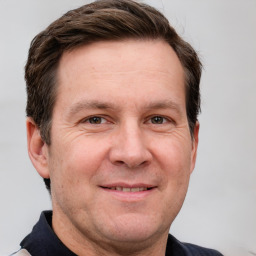 Joyful white adult male with short  brown hair and grey eyes