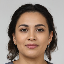 Joyful latino young-adult female with medium  brown hair and brown eyes