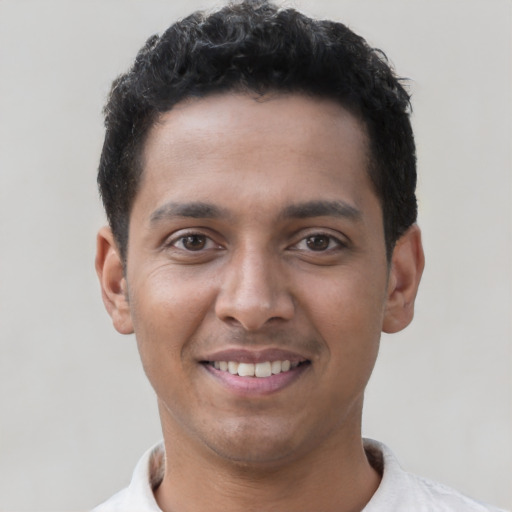 Joyful latino young-adult male with short  brown hair and brown eyes