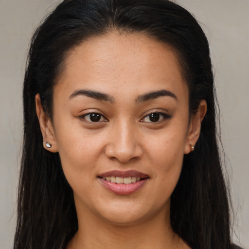 Joyful latino young-adult female with long  brown hair and brown eyes