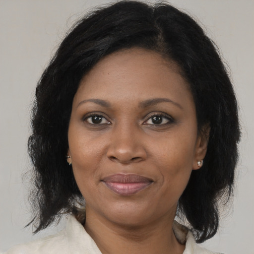 Joyful black adult female with medium  brown hair and brown eyes