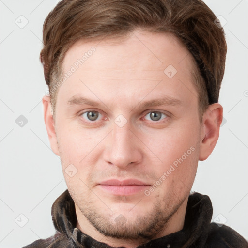 Joyful white young-adult male with short  brown hair and grey eyes