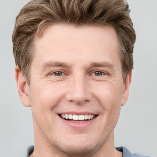 Joyful white adult male with short  brown hair and grey eyes