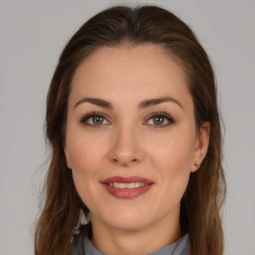 Joyful white young-adult female with long  brown hair and brown eyes