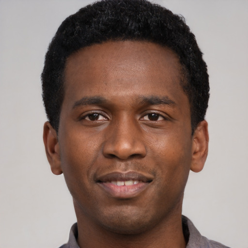 Joyful black young-adult male with short  black hair and brown eyes