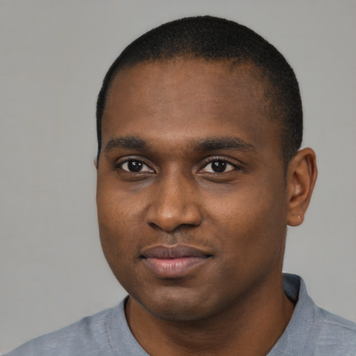 Joyful black young-adult male with short  black hair and brown eyes
