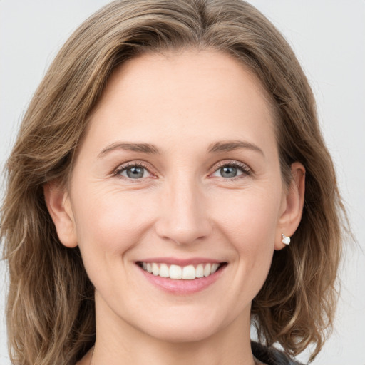 Joyful white young-adult female with long  brown hair and green eyes