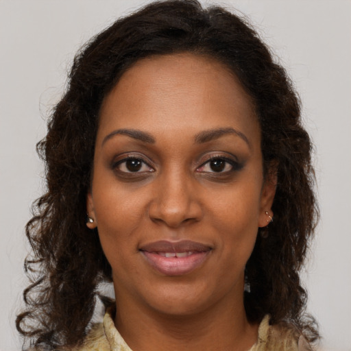 Joyful black young-adult female with medium  brown hair and brown eyes