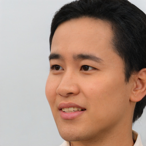 Joyful asian young-adult male with short  black hair and brown eyes