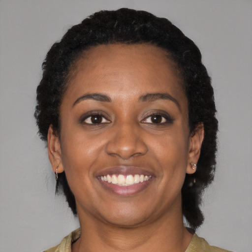 Joyful black adult female with short  black hair and brown eyes