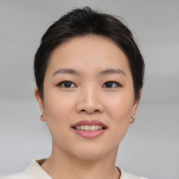 Joyful asian young-adult female with short  brown hair and brown eyes