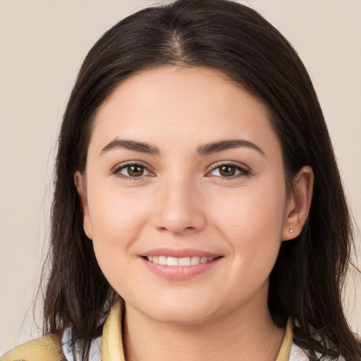 Joyful white young-adult female with long  brown hair and brown eyes