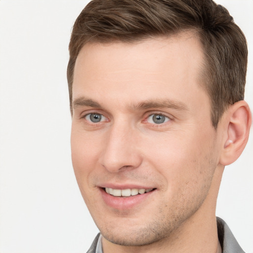 Joyful white young-adult male with short  brown hair and grey eyes