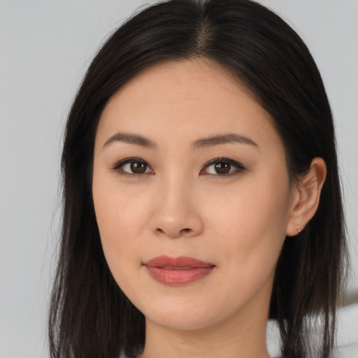 Joyful asian young-adult female with long  brown hair and brown eyes