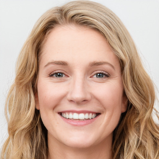 Joyful white young-adult female with long  brown hair and blue eyes