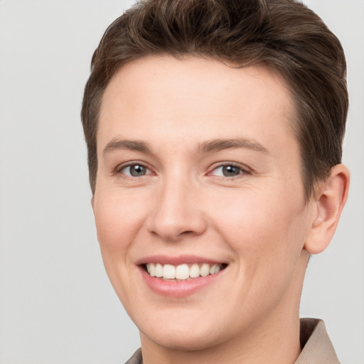 Joyful white young-adult female with short  brown hair and grey eyes