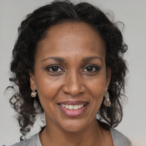 Joyful black adult female with medium  brown hair and brown eyes
