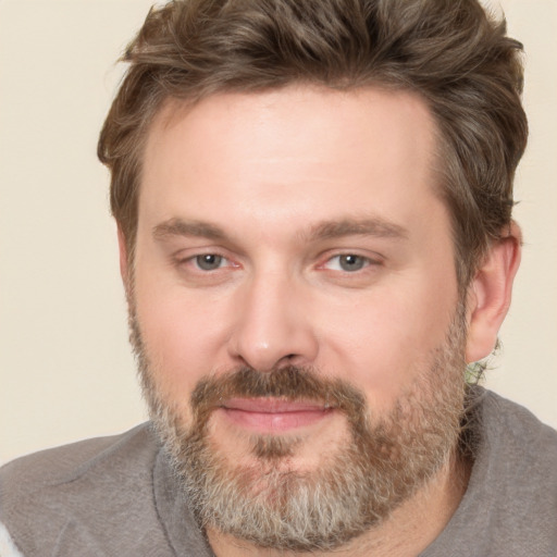 Joyful white adult male with short  brown hair and brown eyes