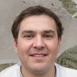 Joyful white young-adult male with short  brown hair and grey eyes