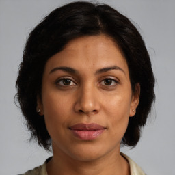 Joyful latino young-adult female with medium  brown hair and brown eyes