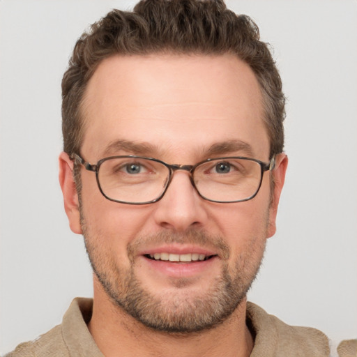 Joyful white adult male with short  brown hair and grey eyes