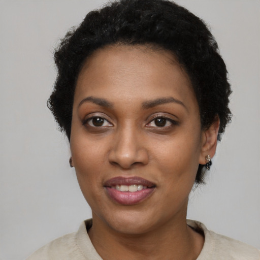 Joyful black young-adult female with short  black hair and brown eyes