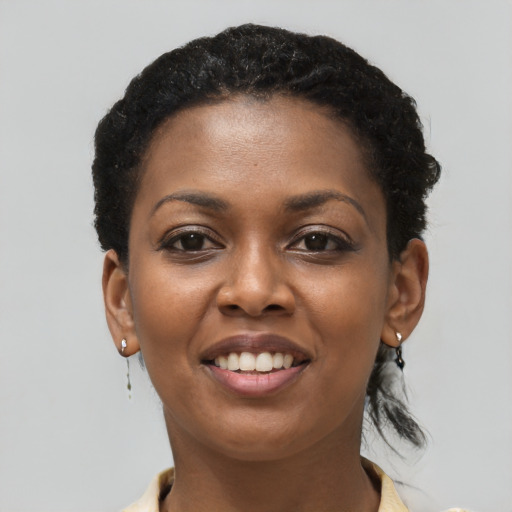 Joyful black young-adult female with short  black hair and brown eyes