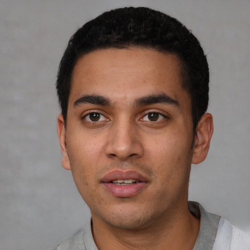 Joyful latino young-adult male with short  black hair and brown eyes