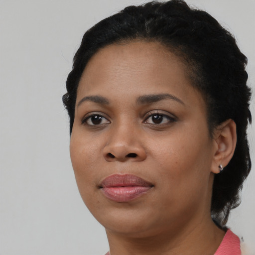 Joyful black young-adult female with short  black hair and brown eyes
