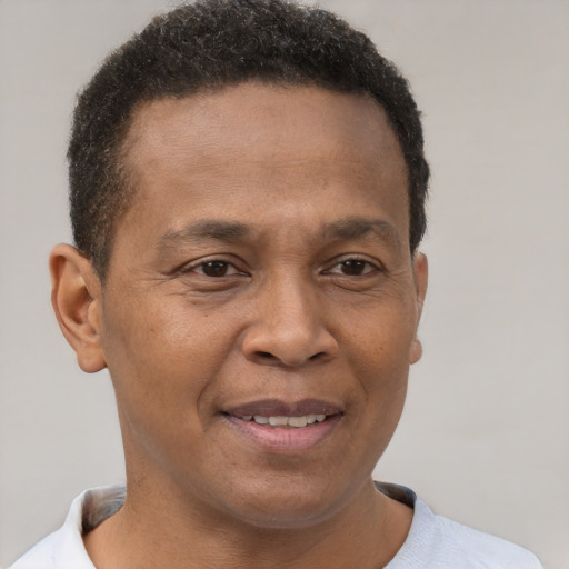 Joyful black young-adult male with short  brown hair and brown eyes