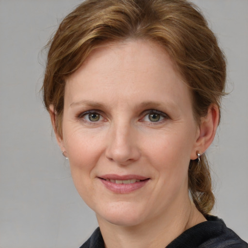 Joyful white adult female with medium  brown hair and blue eyes