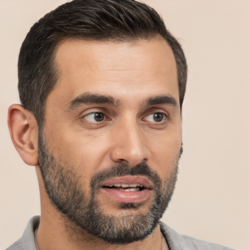 Joyful white young-adult male with short  black hair and brown eyes