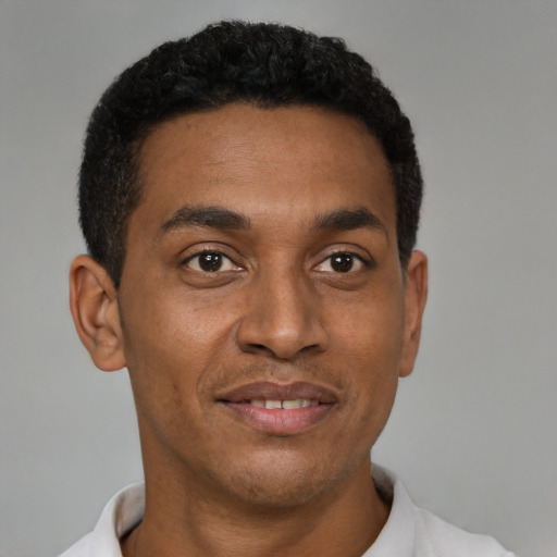 Joyful black young-adult male with short  black hair and brown eyes