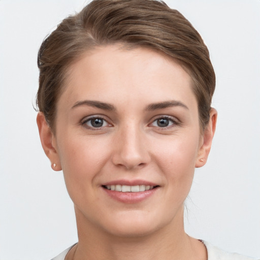 Joyful white young-adult female with short  brown hair and grey eyes