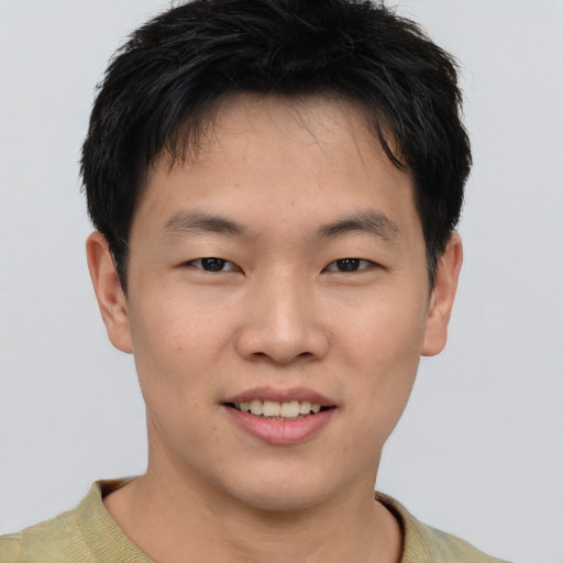 Joyful asian young-adult male with short  brown hair and brown eyes