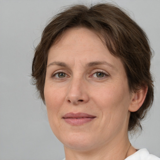 Joyful white adult female with medium  brown hair and green eyes