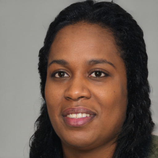 Joyful black young-adult female with long  black hair and brown eyes