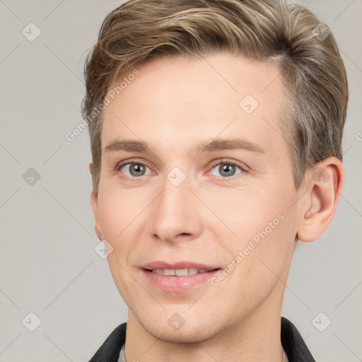 Joyful white young-adult male with short  brown hair and grey eyes