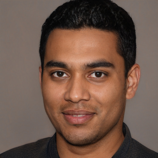 Joyful latino young-adult male with short  black hair and brown eyes