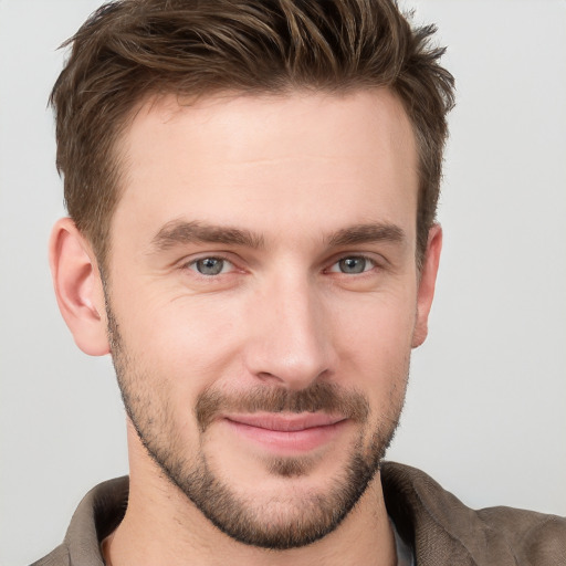 Joyful white young-adult male with short  brown hair and grey eyes