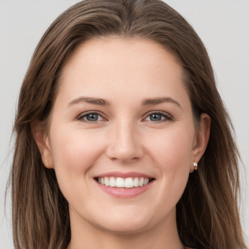 Joyful white young-adult female with long  brown hair and grey eyes