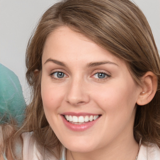 Joyful white young-adult female with medium  brown hair and blue eyes