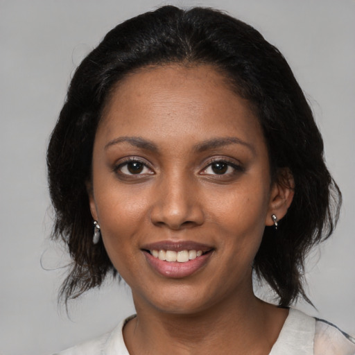 Joyful black young-adult female with medium  black hair and brown eyes