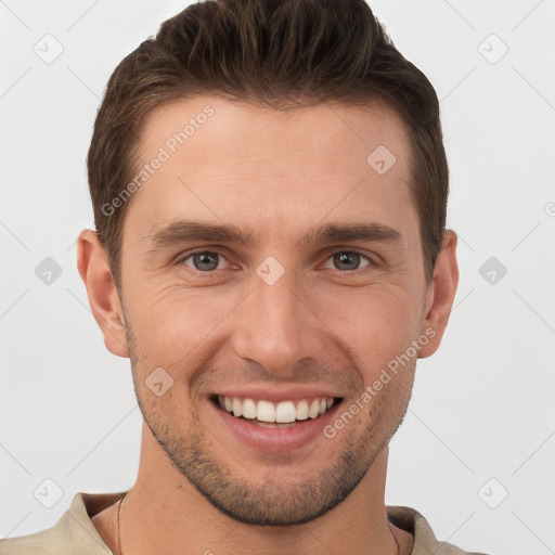 Joyful white young-adult male with short  brown hair and grey eyes