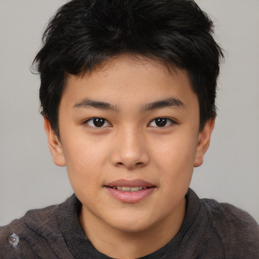 Joyful asian child male with short  brown hair and brown eyes