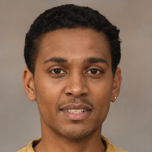 Joyful latino young-adult male with short  brown hair and brown eyes