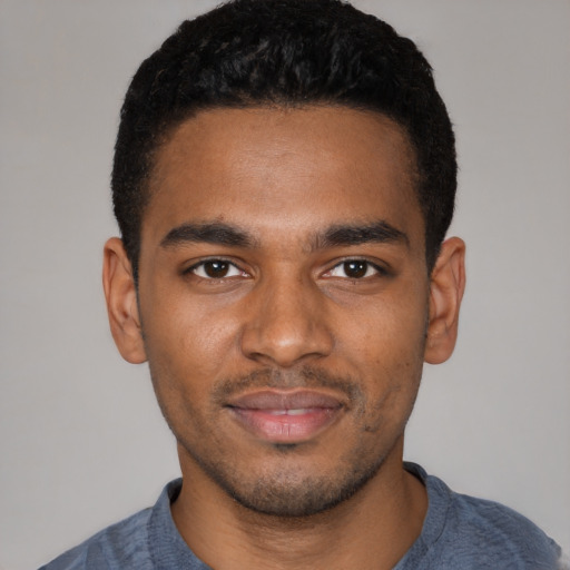 Joyful black young-adult male with short  black hair and brown eyes